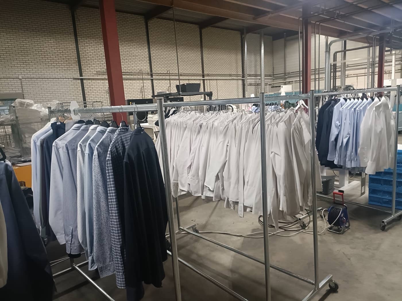 De werkruimte van Wasserij Lividus met rekken vol schoon gewassen en gestreken overhemden