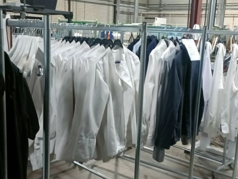 Rekken met schone overhemden en kostuums